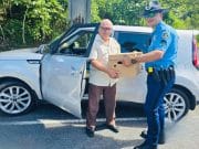 Policía entrega caja con alimentos a transeúntes en Utuado